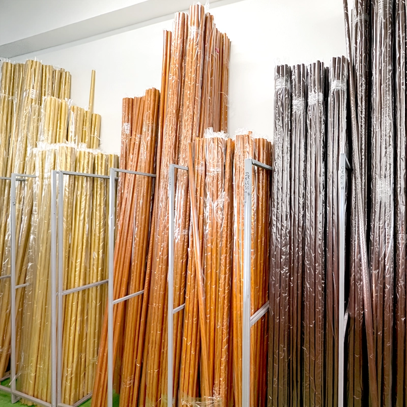 Drevené garnížové tyče v rôznych odtieňoch dreva, usporiadané v sklade